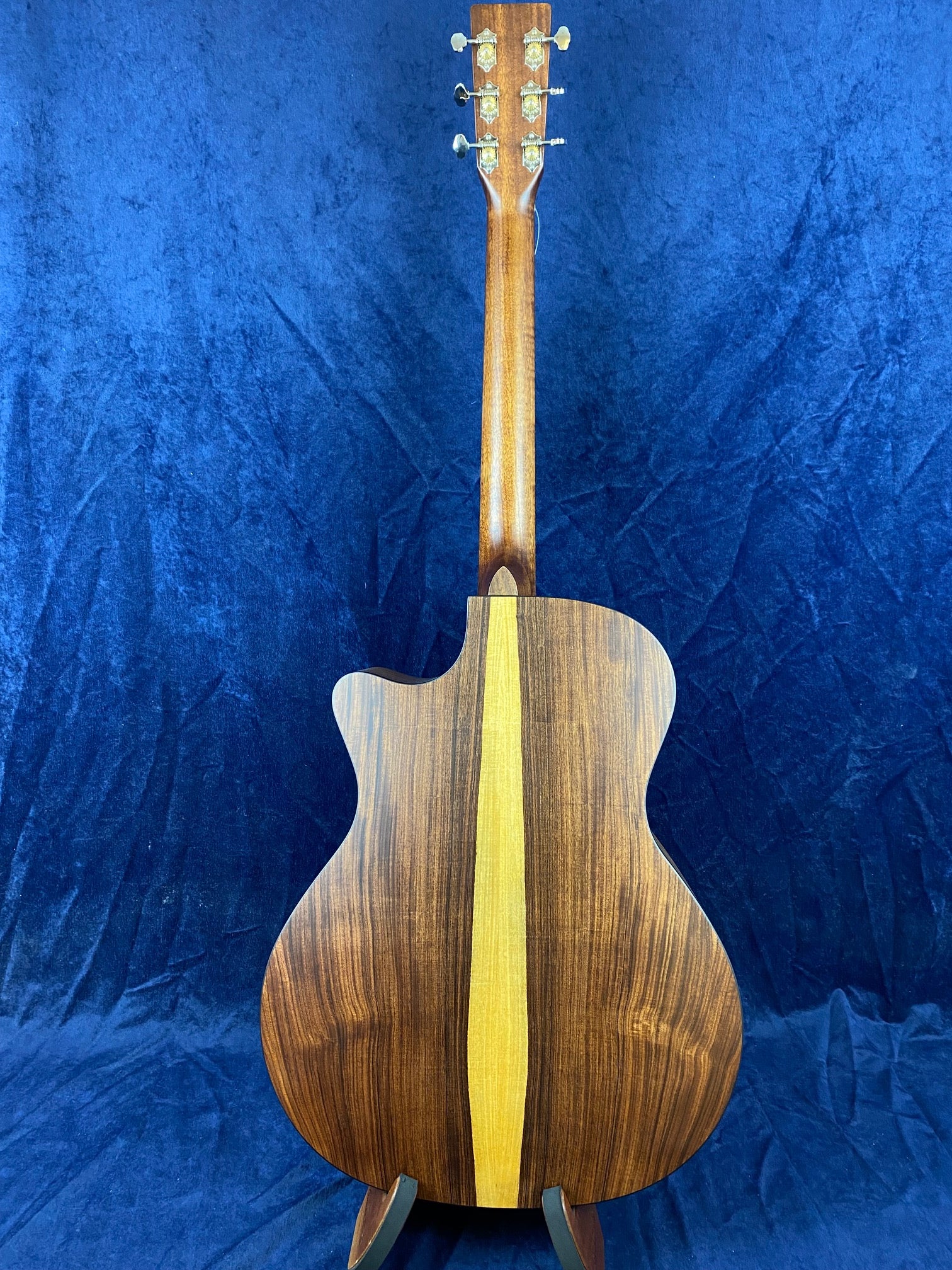 Acoustic guitar shown from the back, featuring a dark wood body with a striking vertical light wood stripe down the center.