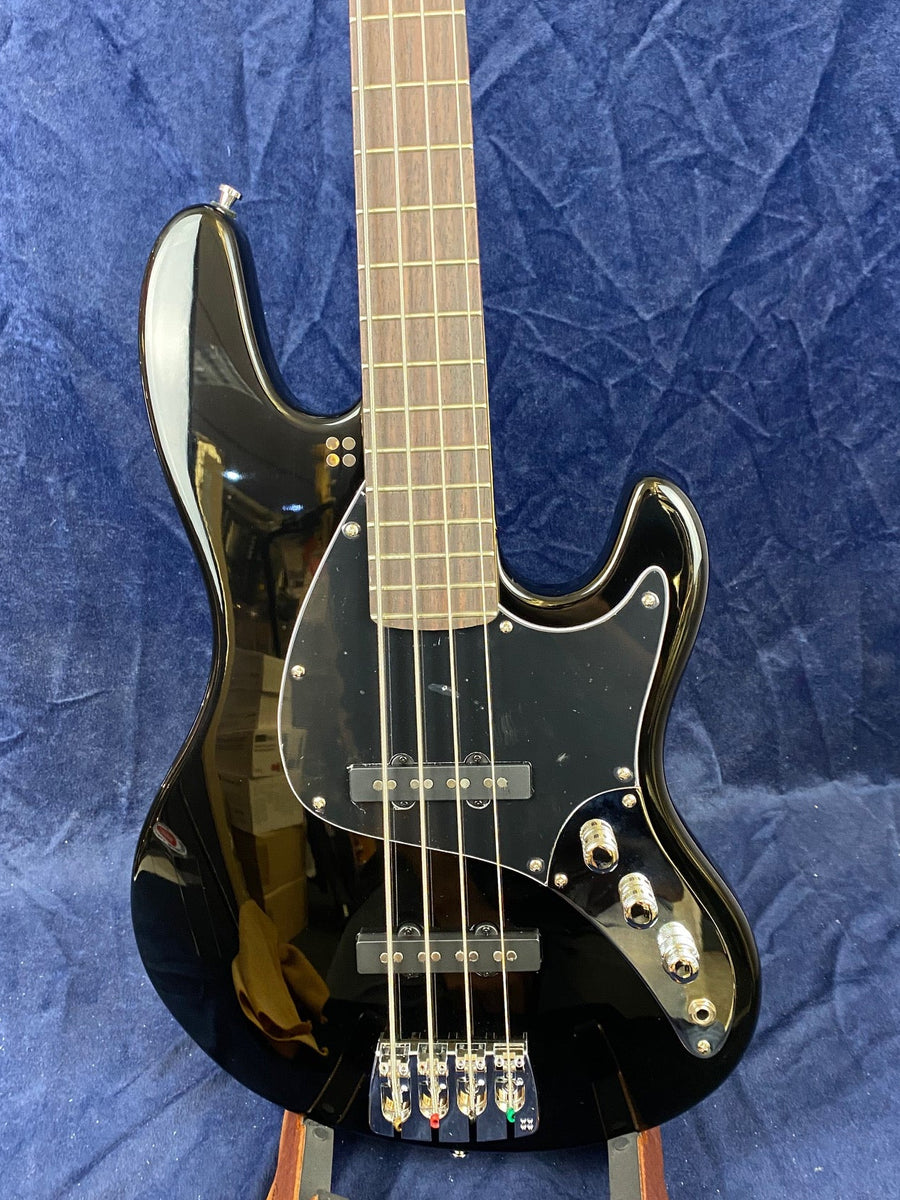 Glossy black electric bass guitar with four strings, chrome hardware, three control knobs, and a dark wood fretboard set against a blue background.
