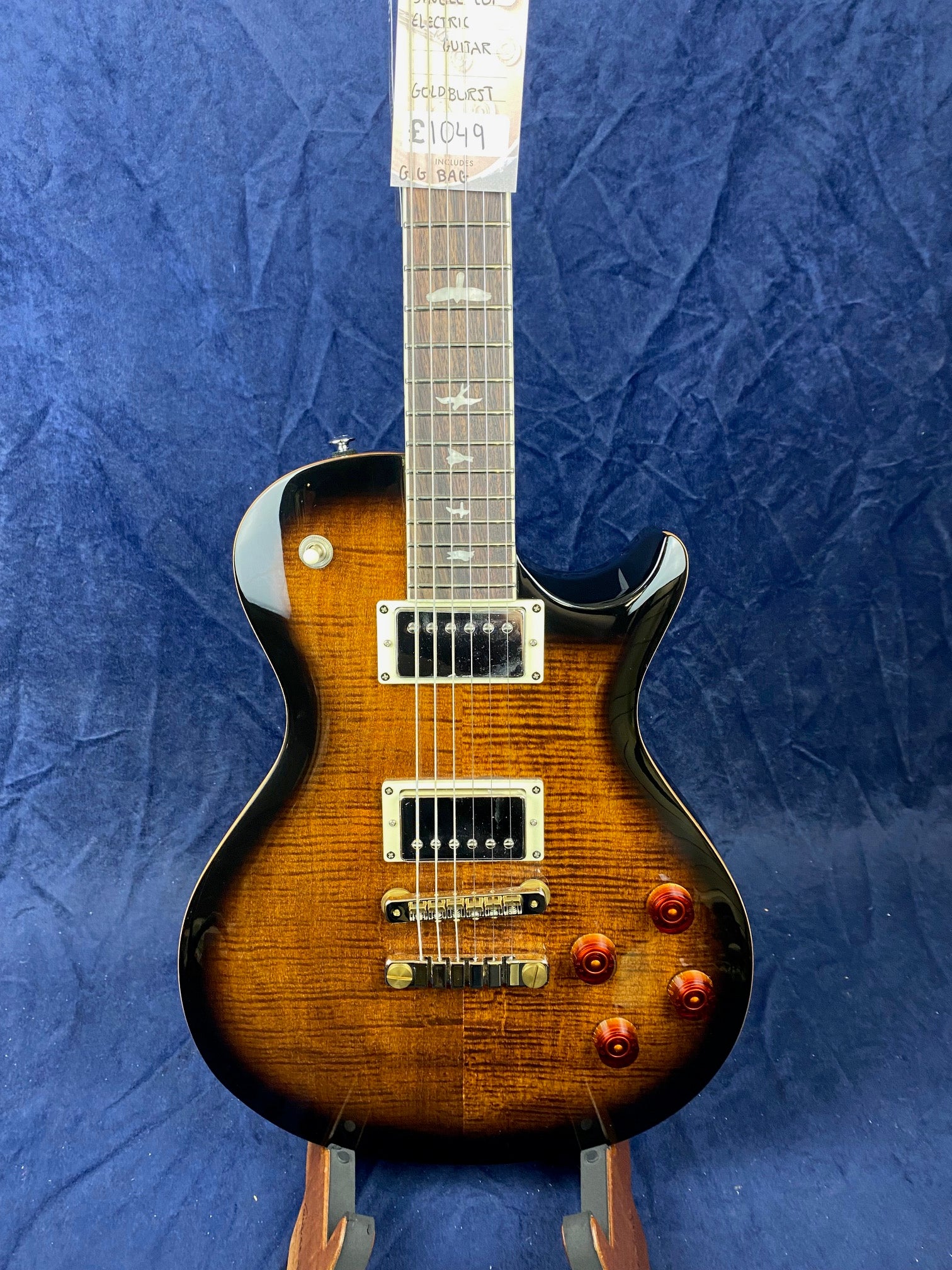 Electric guitar with a flamed maple top in a goldburst finish, four amber knobs, two humbucker pickups, and bird inlays on the fretboard.