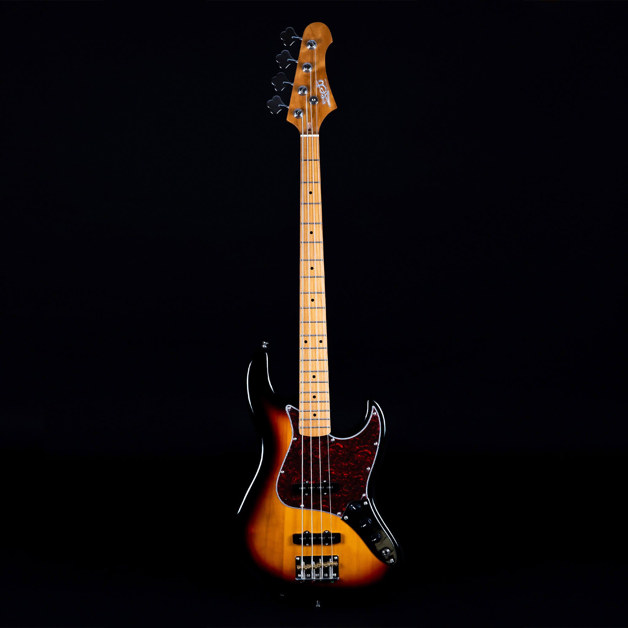 Sunburst finish bass guitar with a brown-black gradient body, four metal strings, light maple neck, and a dark pickguard against a black background.
