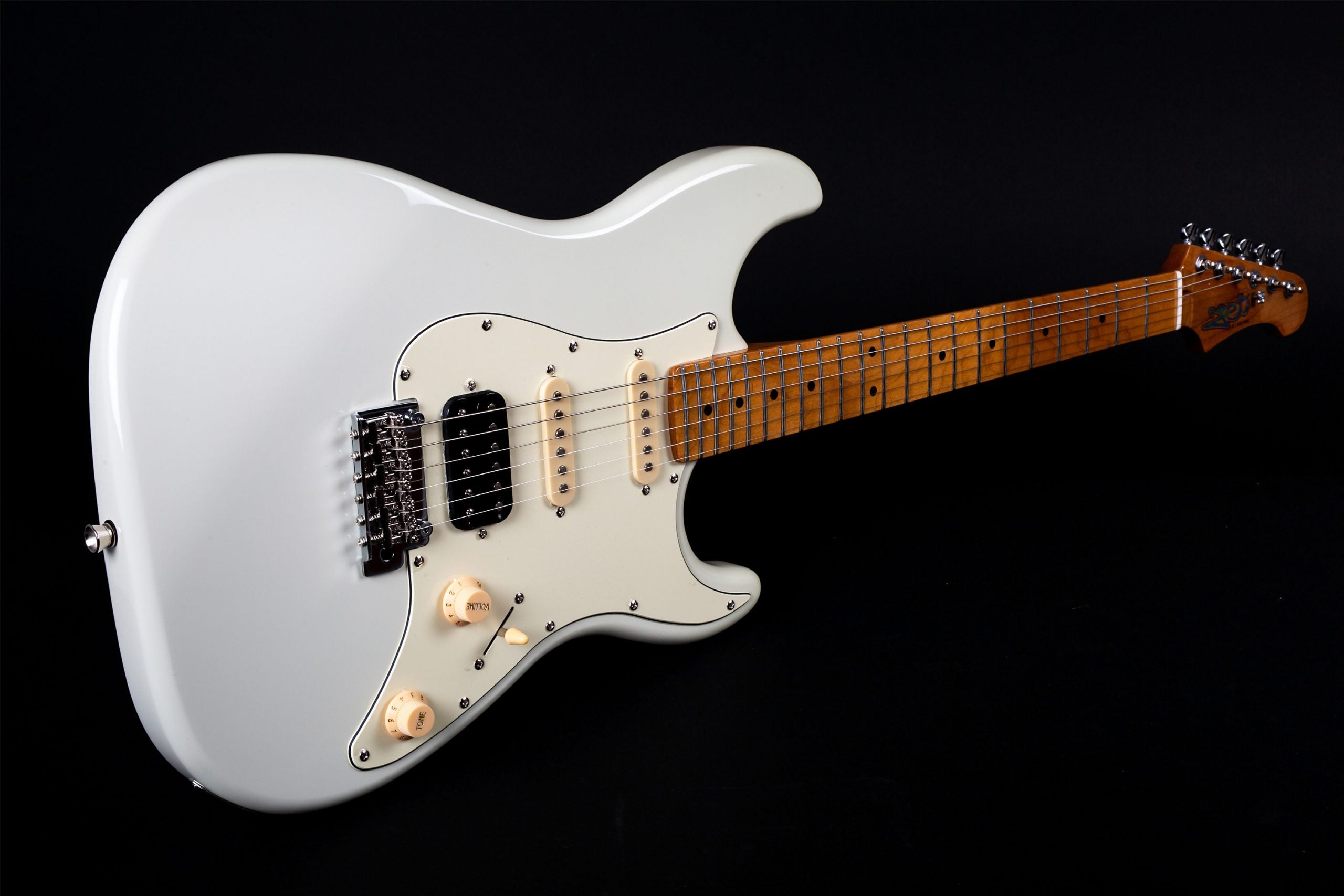 White electric guitar with a light wood neck, three pickups, two control knobs, and a five-way switch on a dark background.