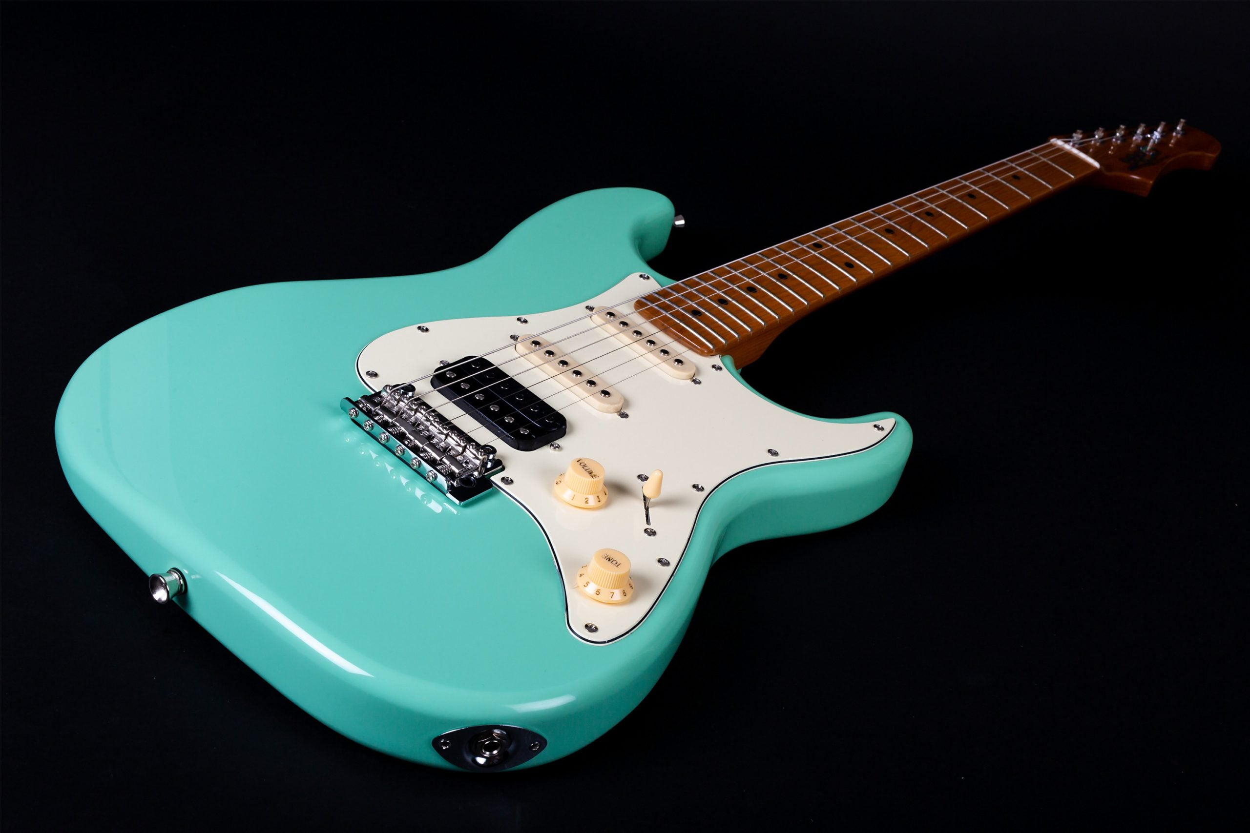 Guitare électrique turquoise avec plaque blanche, trois micros, deux boutons de réglage crème et un manche marron à touche claire.