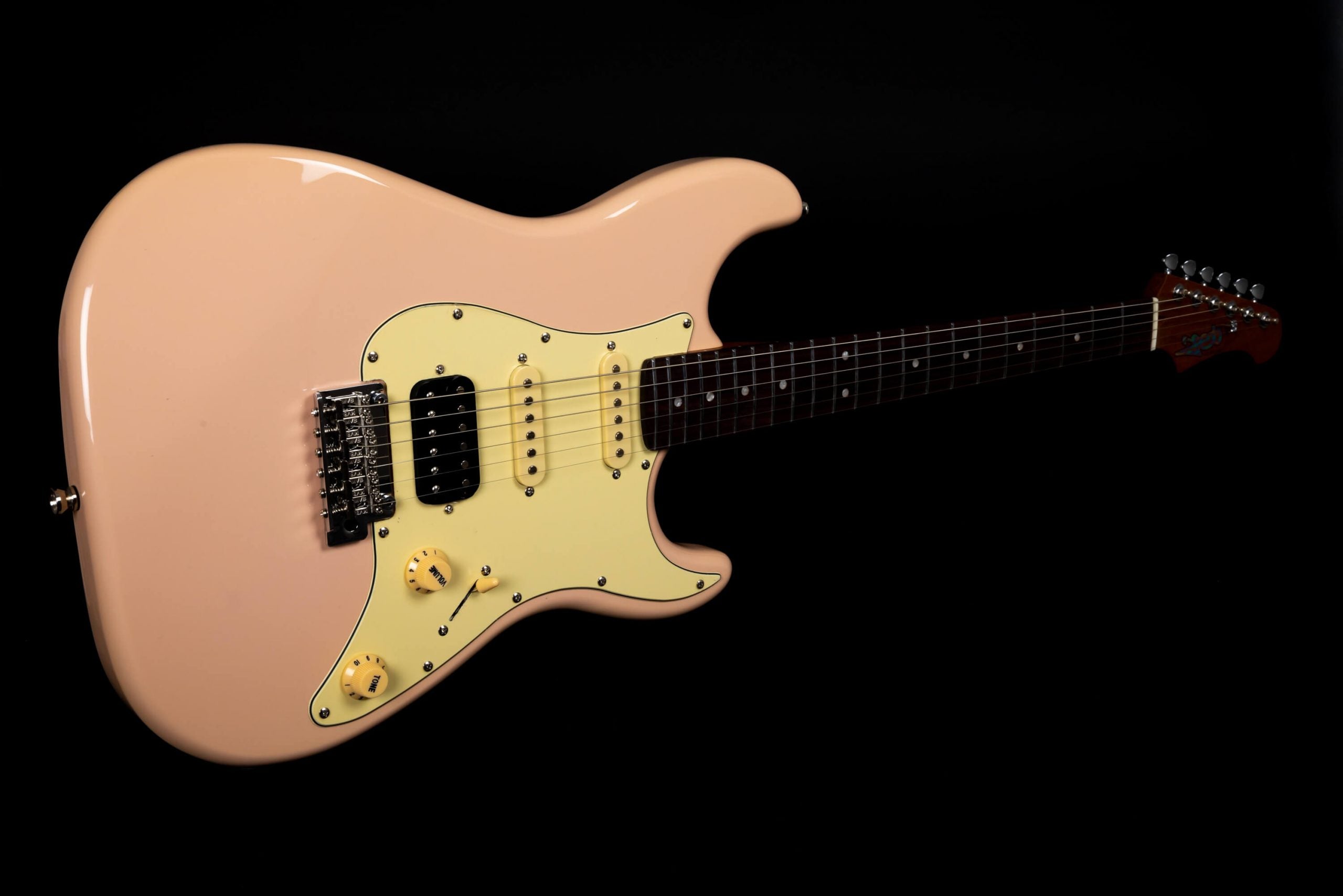 Peach-colored electric guitar with a cream pickguard, two yellow control knobs, three pickups, and a dark brown fretboard.