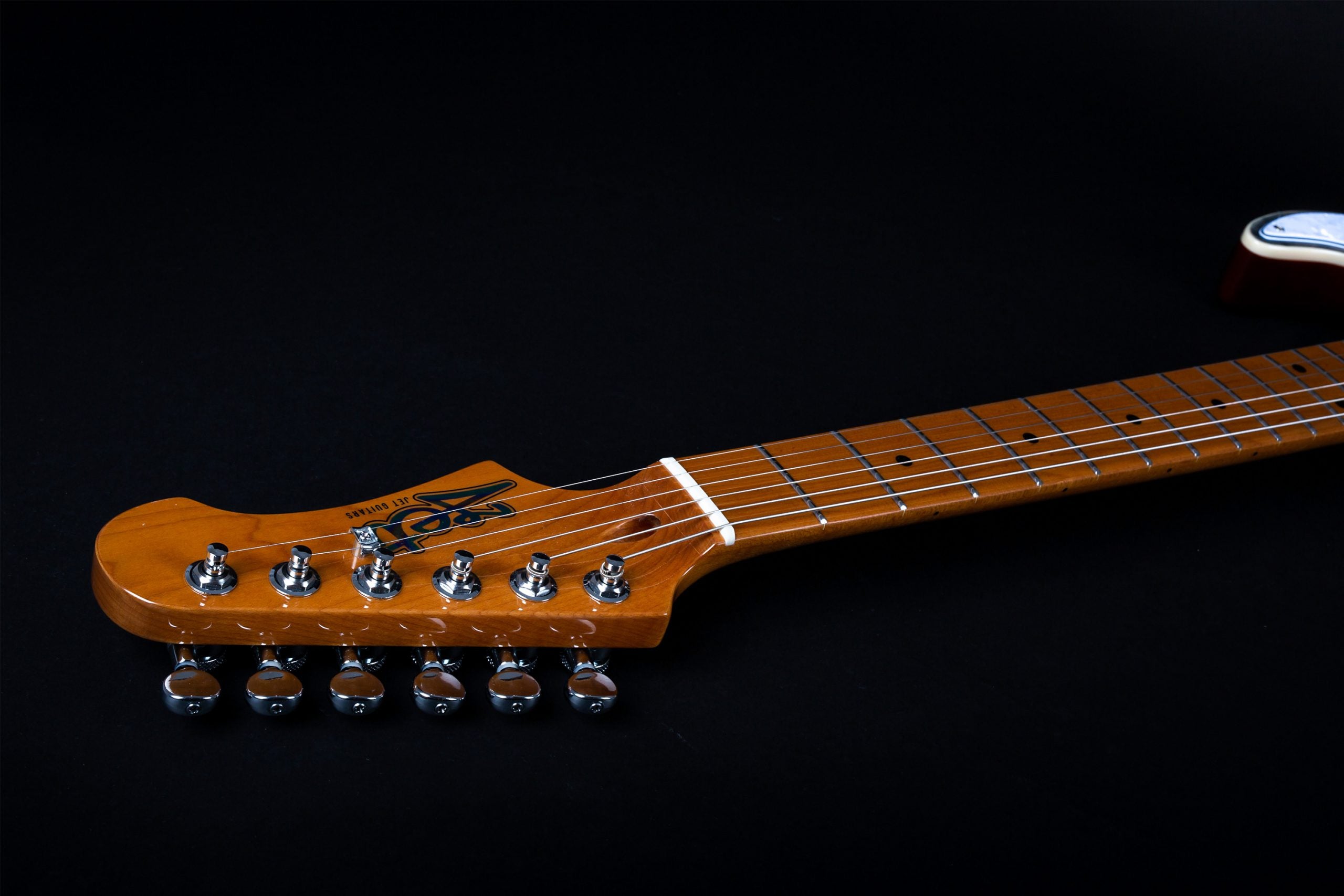 Glossy maple electric guitar neck and headstock with six chrome tuning pegs, silver frets, and black dot inlays on a black background.