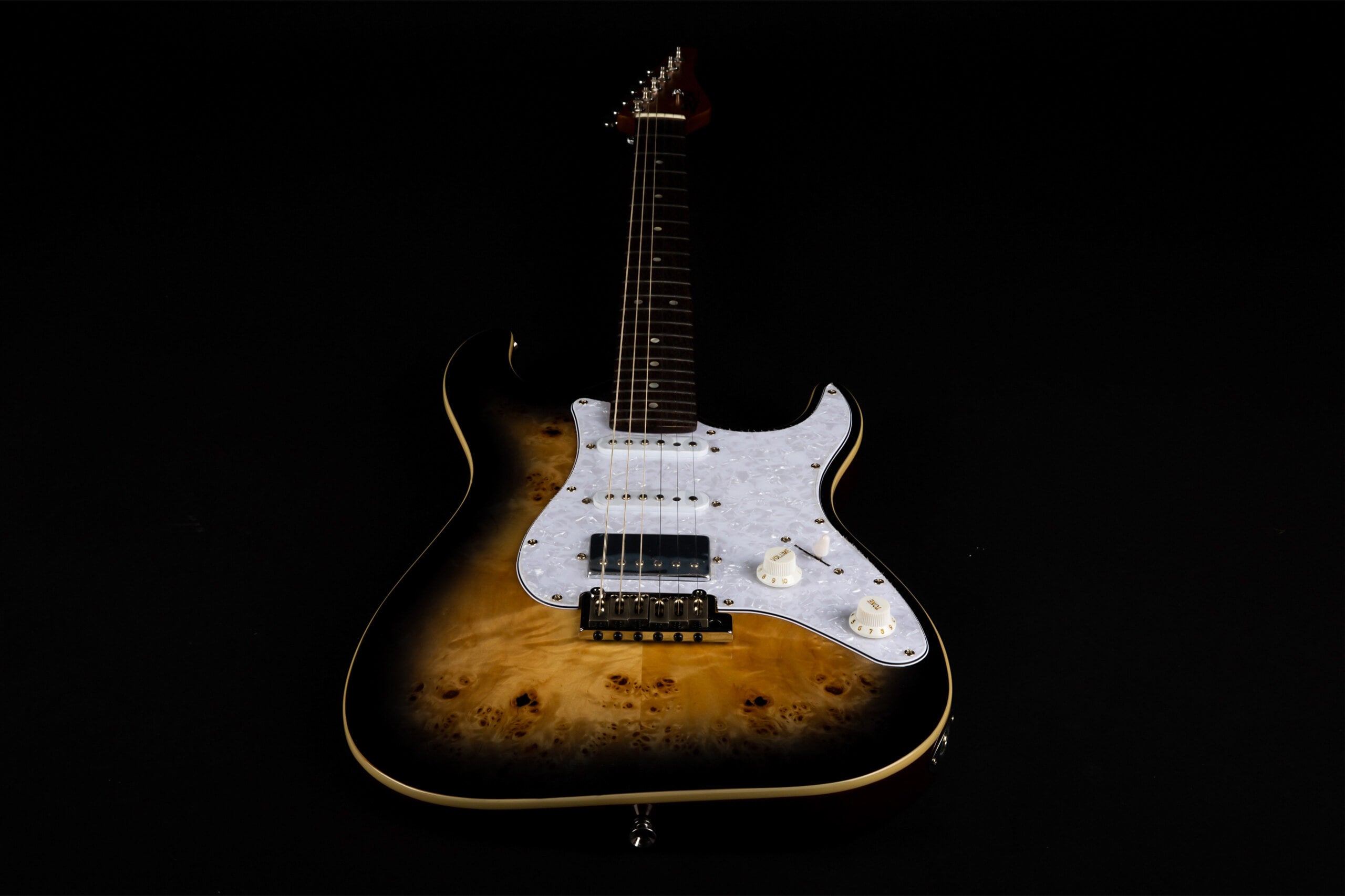 Electric guitar with a glossy brown-to-black burst finish, white pickguard, three pickups, and two white control knobs, shown on a black background.