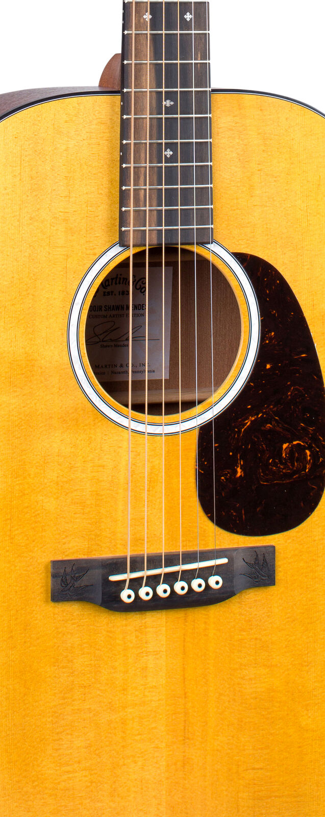 Light wood acoustic guitar body with a black pickguard, six white bridge pins, and decorative inlays on a dark bridge and fingerboard.