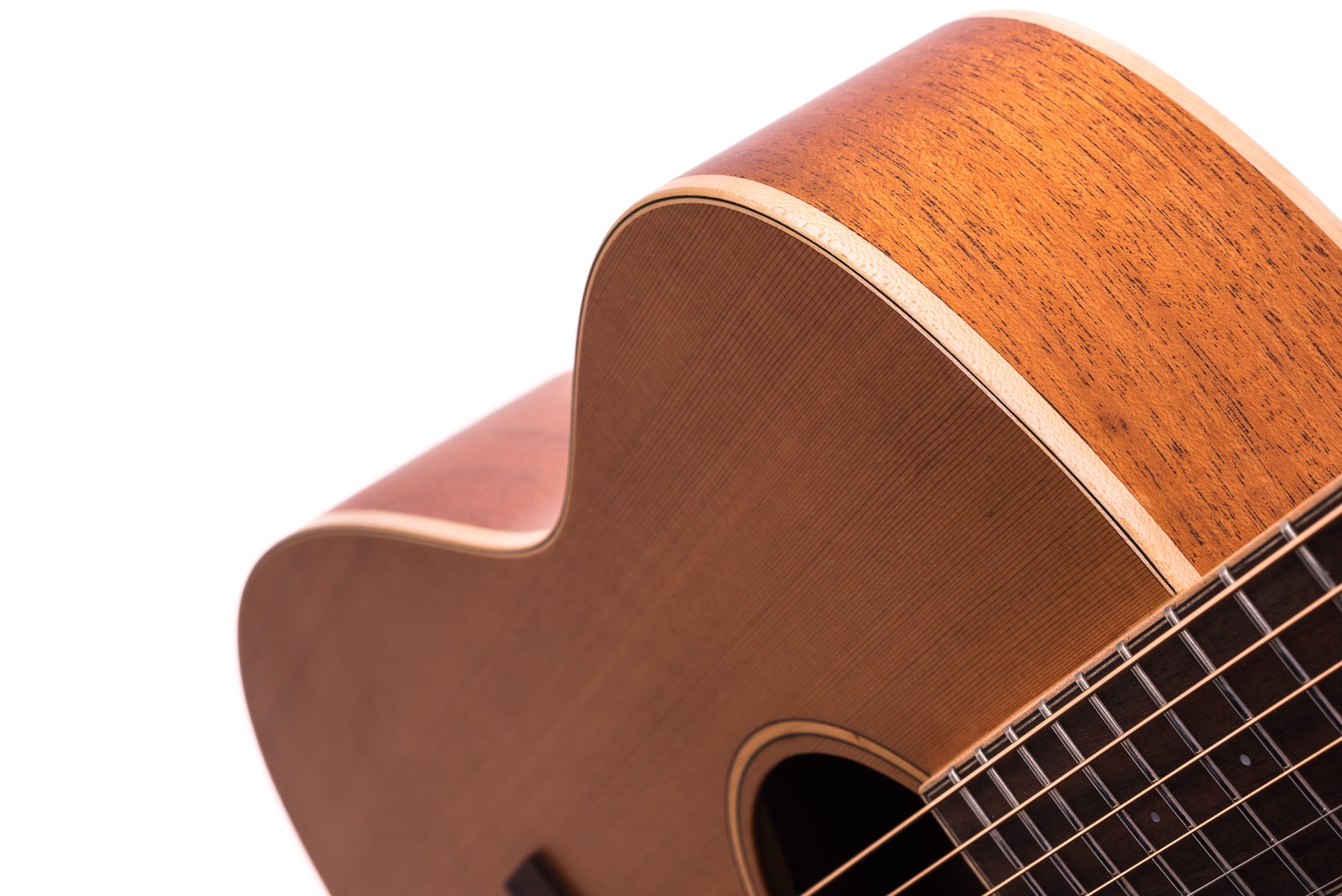 Close-up of an acoustic guitar’s wooden body and soundhole, showing the strings, frets, and curved cutaway against a white background.