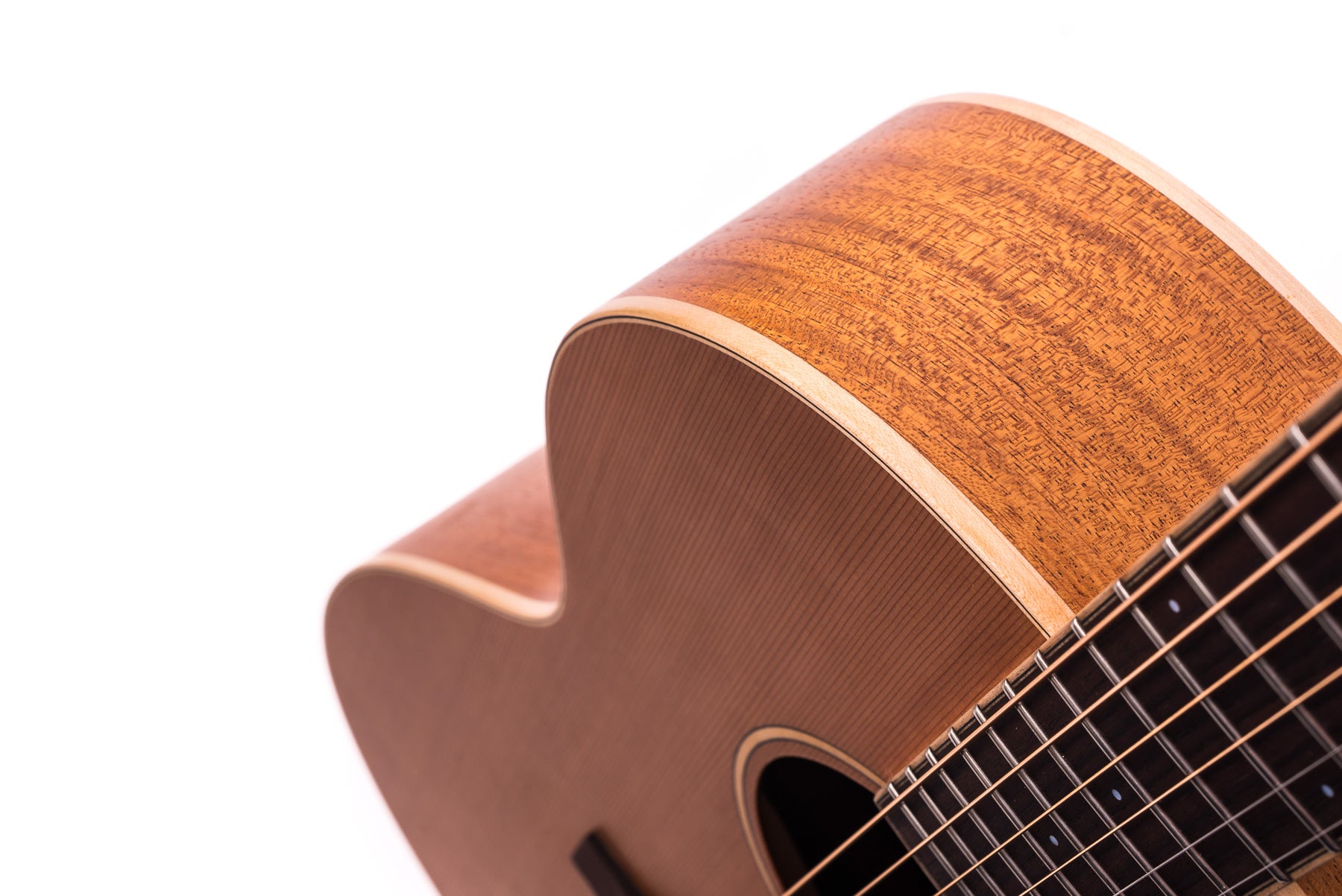 Curved acoustic guitar body in natural wood with visible grain, cutaway design, strings and part of the fretboard shown diagonally.