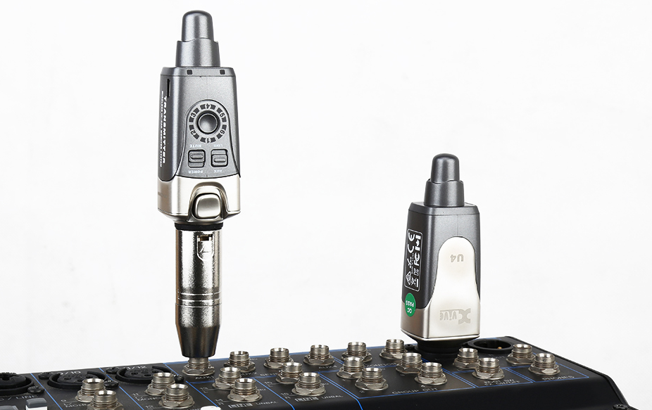 Two wireless audio transmitter and receiver devices plugged into an audio mixer, each with controls and indicators on their bodies.