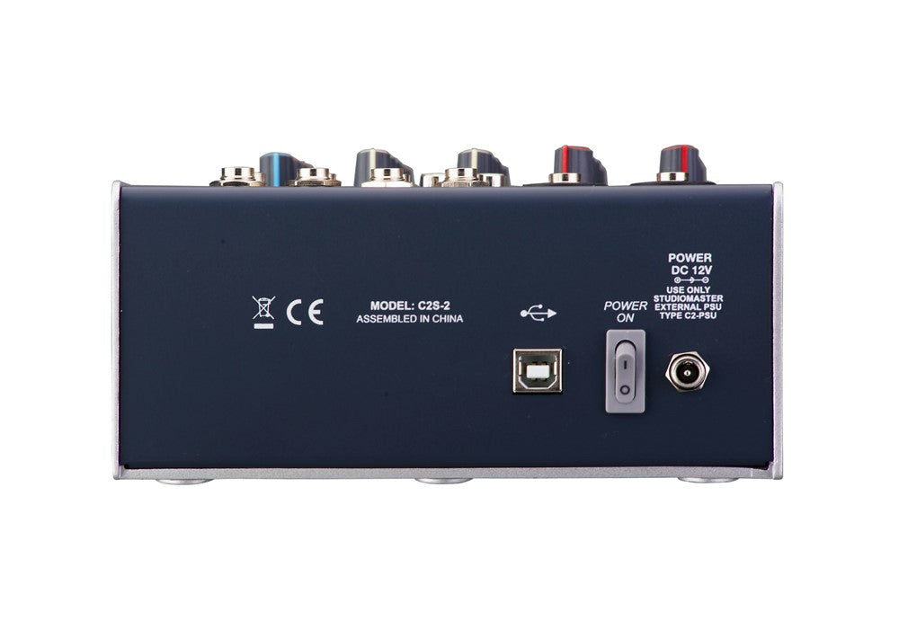 Back panel of a mixing desk showing USB-B port, power switch, 12V DC input, and multiple audio input jacks on the top edge.
