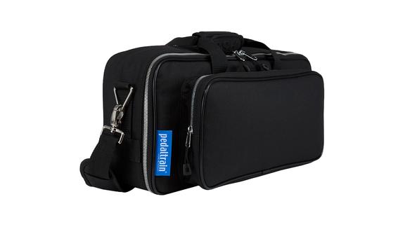 Black soft carrying case with a large zippered pocket on the front, side handle, shoulder strap, and Pedaltrain logo tag. Used for transporting gear.