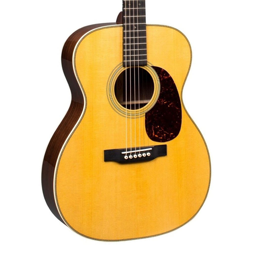 Acoustic guitar with a light wood top, dark sides, six strings, black bridge, and a tortoiseshell-style pickguard below the sound hole.