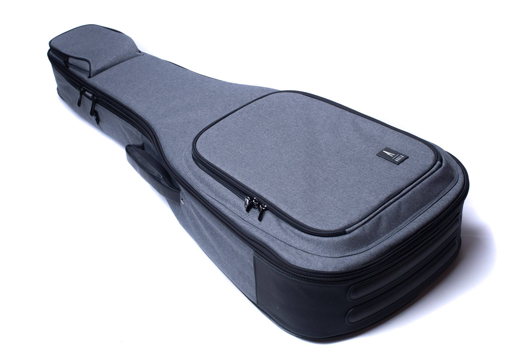 A gray soft acoustic guitar case with black zippers, padded handles, and a large front pocket for accessories.