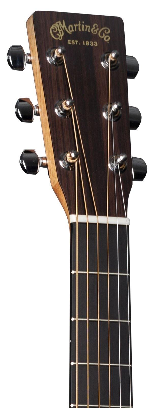Close-up view of a Martin & Co acoustic guitar headstock, six tuning pegs, steel strings, and part of the fretboard are visible.