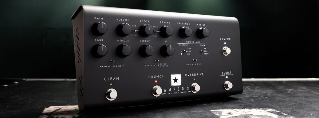 Black guitar amplifier pedal with multiple control knobs and labeled footswitches for clean, crunch, overdrive, boost, and reverb settings.