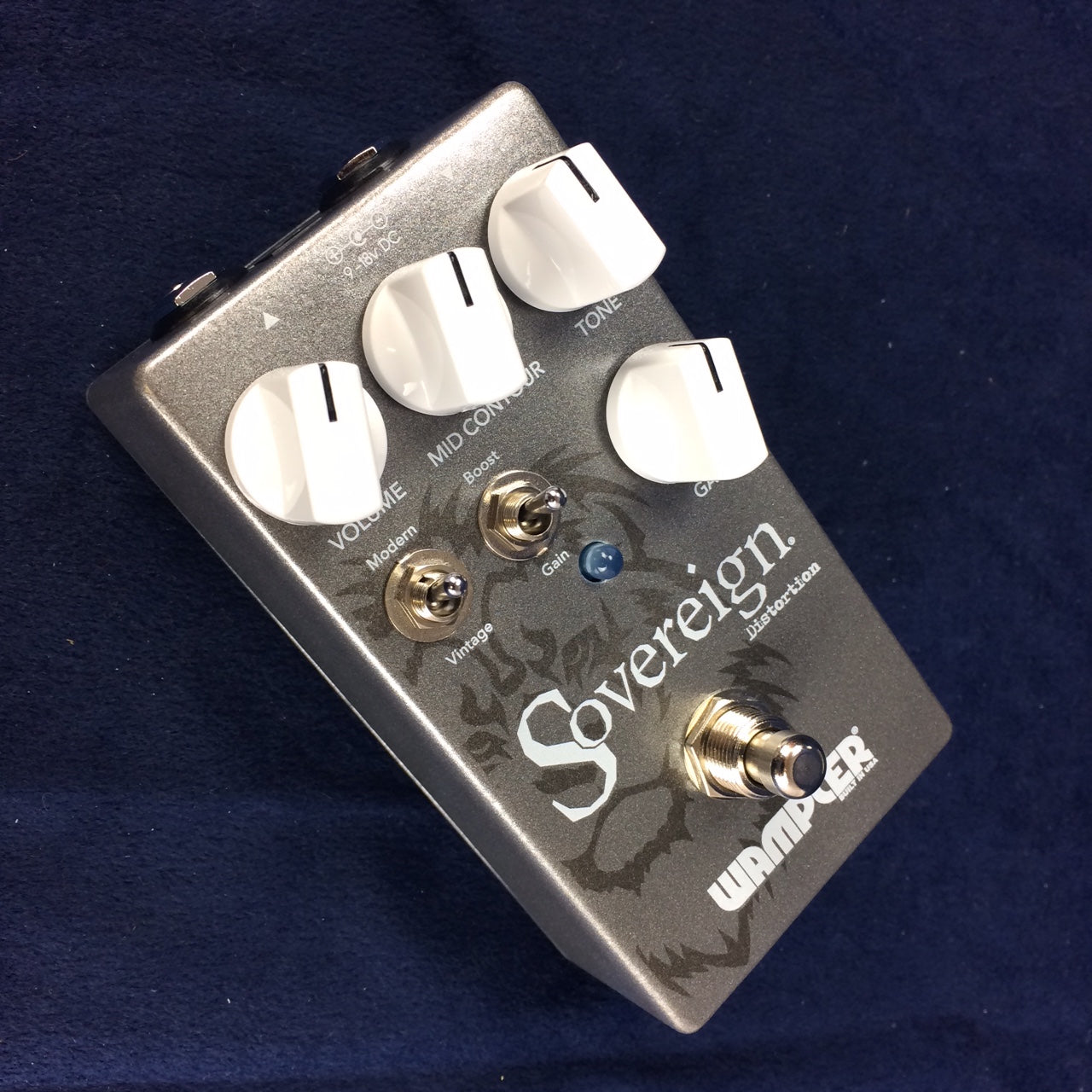 Wampler Sovereign distortion effects pedal with four large white knobs, two small toggle switches, and a silver footswitch on a dark background.