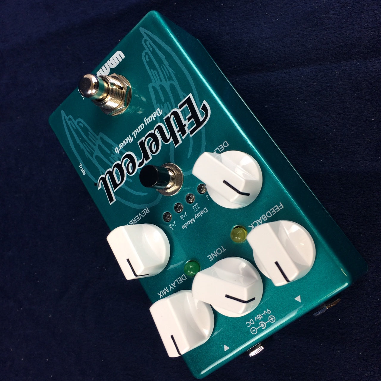 Turquoise guitar effects pedal labeled “Ethereal” with five white knobs, two footswitches, and multiple mode buttons on a dark fabric surface.