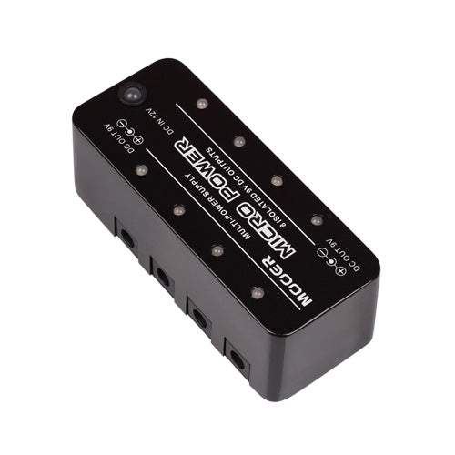 Black effects pedal power supply unit with multiple DC output ports along one side and labeled indicators on the top panel.