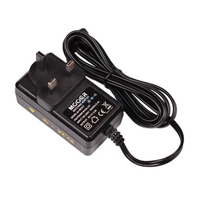 Black plug-in power adapter with UK-style three-prong plug and long attached cord, labeled with voltage, safety symbols, and product information.