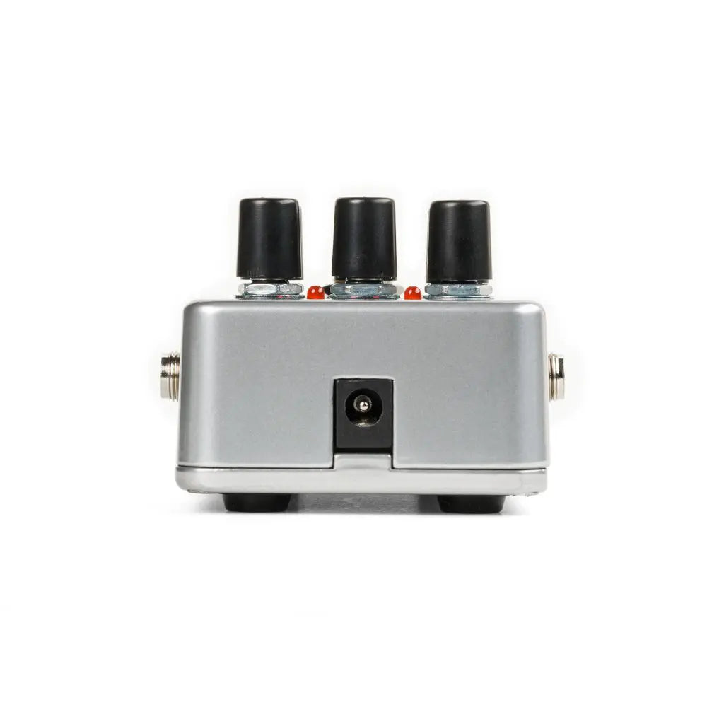 Silver effects pedal with three black knobs on top, power input in the center, and input/output jacks on each side.