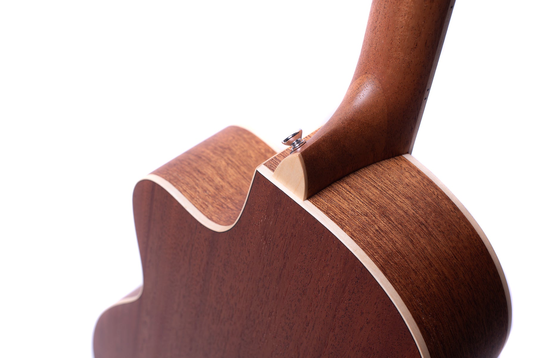 Close-up of an acoustic guitar’s neck joint, showing smooth brown wood, cream binding, and a metal strap button on the heel.