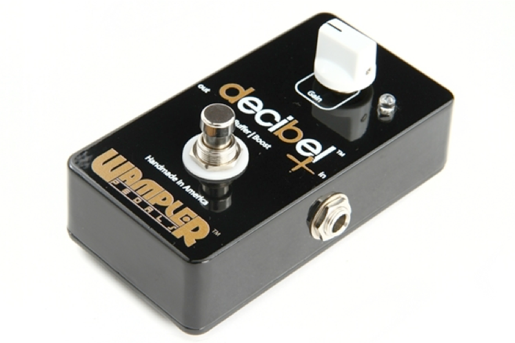 Black Wampler Decibel+ effects pedal with a single white knob labeled Gain, a metal footswitch, and input/output jacks on the sides.