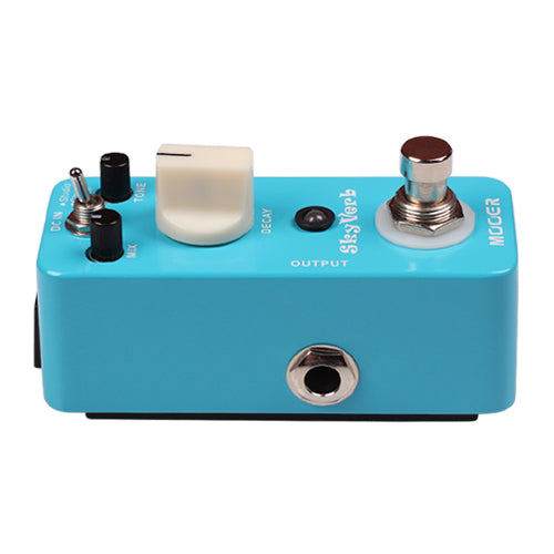Compact blue effects pedal with three small knobs, a large white knob, a toggle switch, a footswitch, and an output jack on the side.