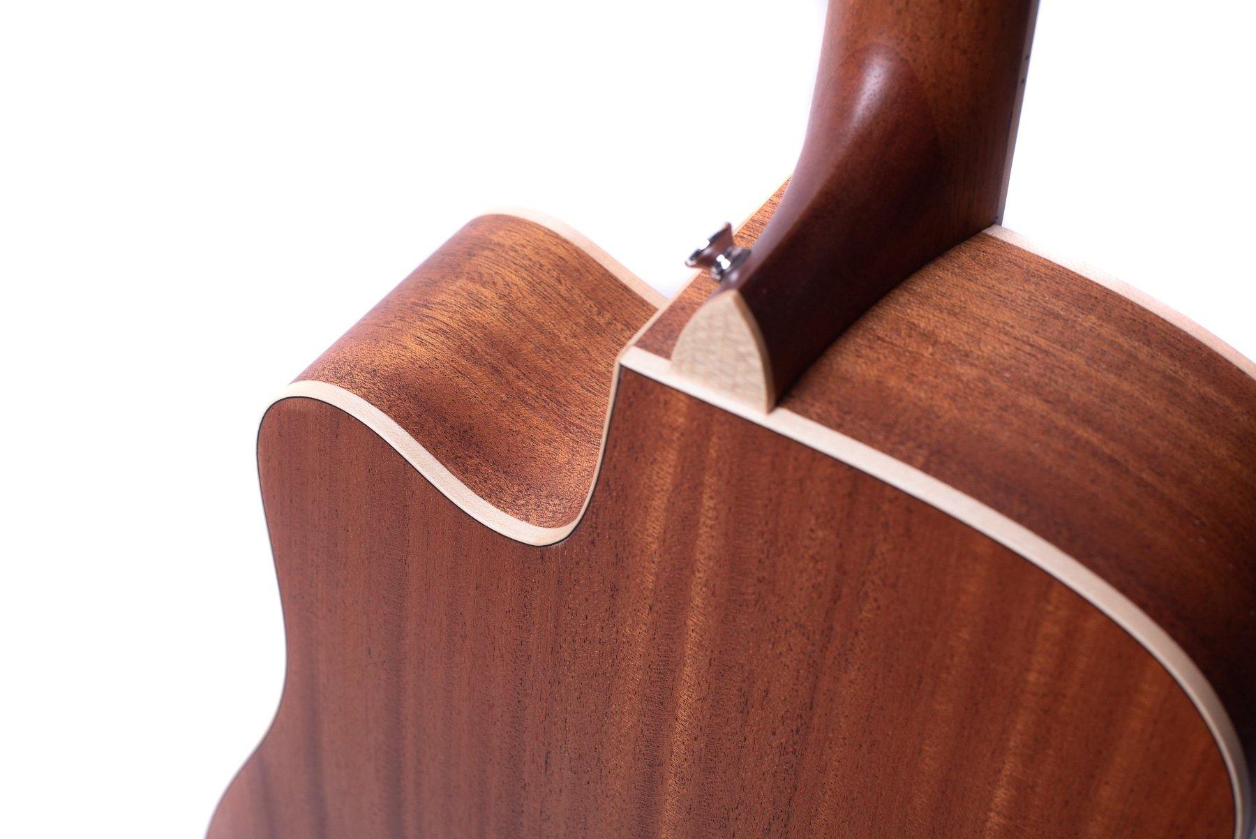 Close-up of an acoustic guitar's wooden body and neck joint, showing smooth brown wood with a light cream binding and a strap button.